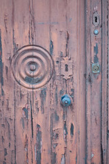 Fototapeta na wymiar Vertical view of part of a husked brown wooden door with several locks, Ciudad Real, Castilla la Mancha, Spain