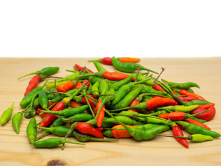 Red and Green hot chilli on a wooden floor.