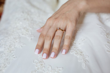 Bride's hand touching details of her wedding dress