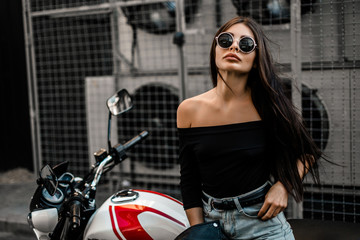 Fototapeta na wymiar Pretty young sexy fashion model posing on the motorcycle.
