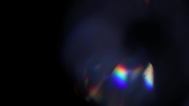 Lens Flare, Abstract Bokeh Lights Moving. Leaking Reflection of a Glass, Crystal, Defocused Shining Colorful rainbow Light Leaks, Rays on Black Background. 4K UHD video
