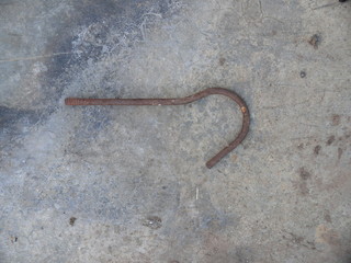 rusty hook from a hanger on a gray background.