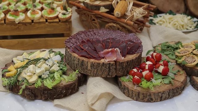 Meat basturma and cheese snacks on wooden plates lay on a table HD