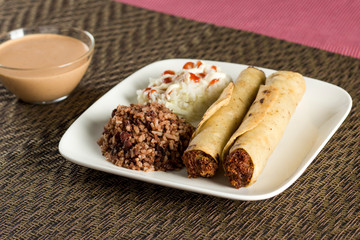 "Tacos" or "flautas nicaragüenses" a typical dinner dish, accompanied by gallo pinto and salad.