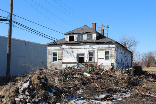 Rubbish illegally dumped in back yard of a Michigan Bunglow in winter in Detroit's Poletown neighborhood