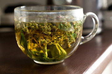 transparent mug with hot herbal mint  tea in a kitchen
