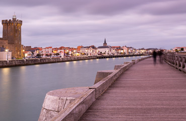 Obraz premium People walking on a seaside bridge in Les Sables-d'Olonne, France