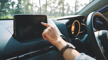 Closeup image a woman using and pointing finger at navigation screen while driving car