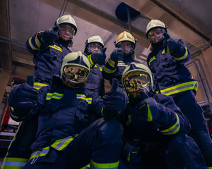 Portrait of group of firefighters wearing protective uniform inside the fire station