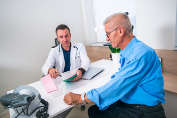Obraz premium Doctor discuss with his elder patient at his office