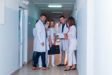 Fototapeta premium Group of medical staff, team doctors and nurses posing in the hallway of a hospital, clinic.