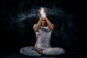 young woman doing yoga poses with flour