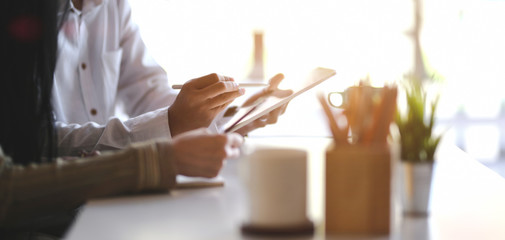 Cropped shot of young designer team working on their concept with tablet in modern office