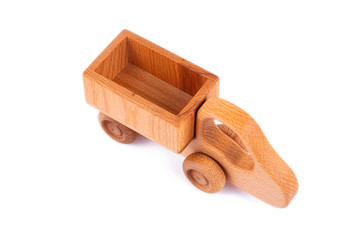 Close-up children's toy made of natural wood in the form of a dump truck  on a white isolated background. Studio photography. Eco-friendly toy for parents and children