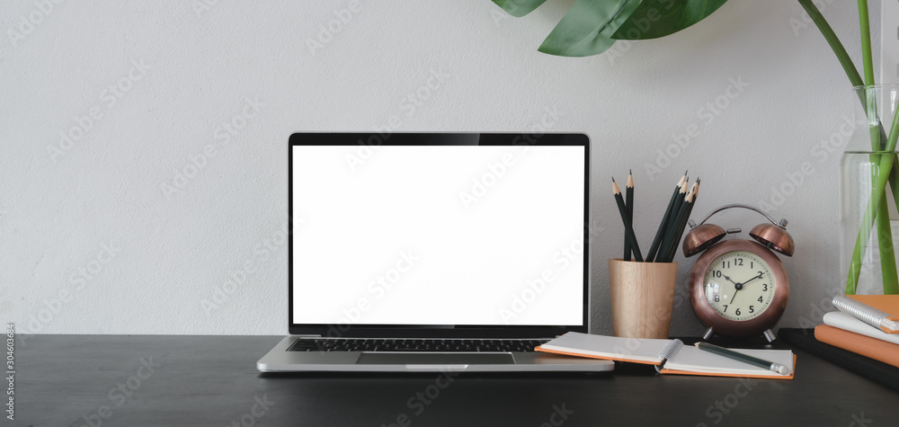 Poster close-up view of open blank screen laptop computer with office supplies in modern office