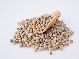 White pepper in wooden spoon isolated on white background