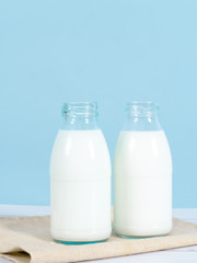 Milk bottle on table with blue background.