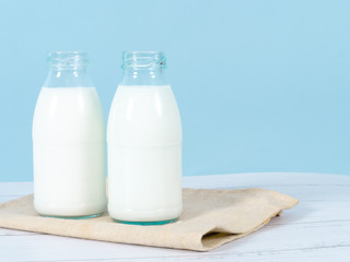 Milk bottle on table with blue background.