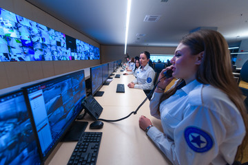 Technical Operator Works at His Workstation with Multiple Displays while talking on the phone,...