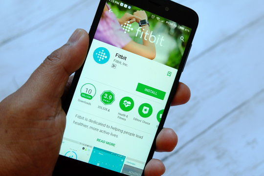 BANDAR SERI BEGAWAN,BRUNEI - JULY 25TH,2018 : A male hand holding smartphone with Fitbit apps on an android Google Play Store