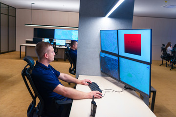In the Security Control Room Officer Monitors Multiple Screens while receiving the alert signal..