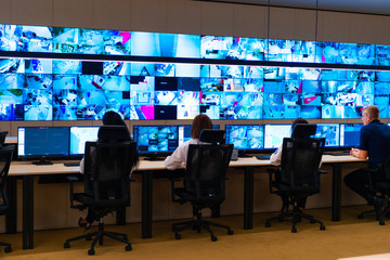 Team of secret agents in uniforms, monitoring cyber, video and communications at the main control data center station.