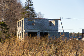 Fototapeta na wymiar Two-storey house under construction from a foam block in a cottage village. Autumn, sunny