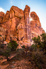 Sun flare between hoodoo sandstone towers in Southern Utah.