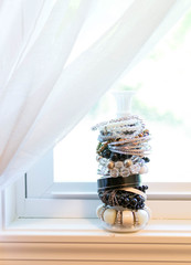 bracelet jewelry on candle stick in front of window with natural light