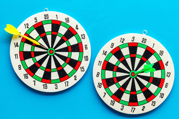 Darts game - simple sport for lesure time. Dartboard and arrows or dart on blue background top view