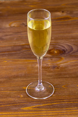 a glass of white wine close up on a wooden background ,drink in wineglass macro