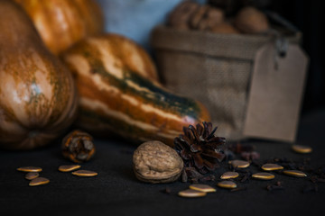 Organic food, still life, diet and nutrition concept. Seasonal autumn vegetables, pumpkins, apples with fall flowers on a table. Copy space, cozy autumn background, toned image. Selective focus.