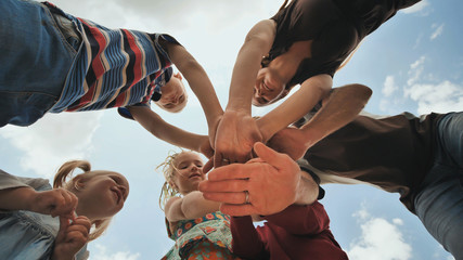 A young family of six join hands together. The concept of a strong and friendly family.