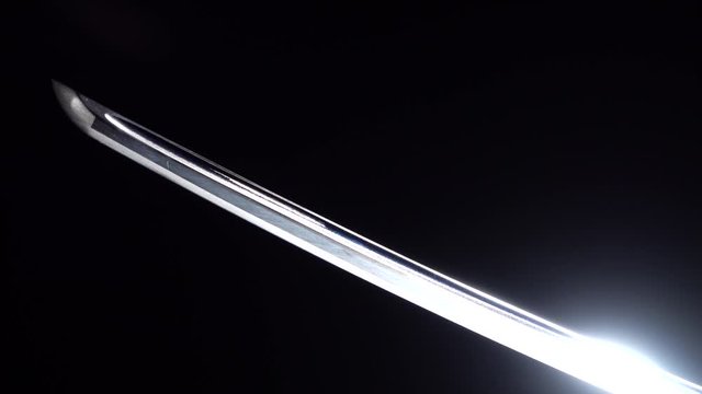 Dramatic studio shot of man holding samurai sword. Close up