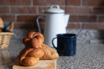 curly bread in a wooden board and a cup of coffee