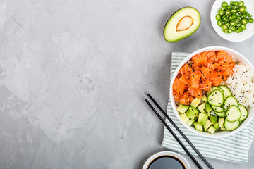 Hawaiian salmon bowl with cucumbers, avocado, sesame seeds and rice. Top view, overhead, flat lay, mock up, template. Healthy food concept