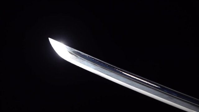 Dramatic studio shot of man holding samurai sword. Close up