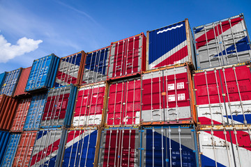 Fototapeta The national flag of United Kingdom on a large number of metal containers for storing goods stacked in rows on top of each other. Conception of storage of goods by importers, exporters obraz