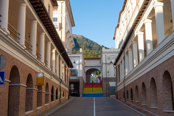 Fototapeta na wymiar The empty street with a multicolored staircase leading up under the arch. Tourist village in the mountains of the Caucasus