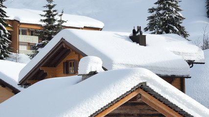 San Bernardino, Switzerland. The roofs of houses covered with fresh snow after heavy snowfall....