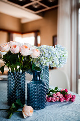 roses and hydrangea in a blue glass vase on the table