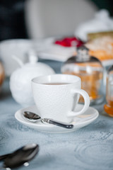 white cup with tea on the table