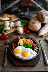 breakfast fried scrambled eggs with sausages and potatoes in a pan on a beautiful background