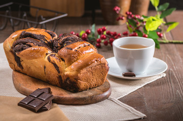 Swirl cake with chocolate on wooden background