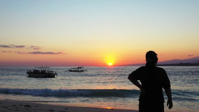 silhouette of a tourist on the sandy beach on sunset. tropical vacation and swimming as a cure for back pain