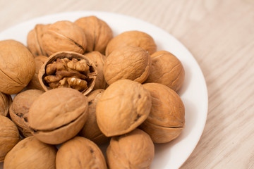 walnuts on a white plate on a woodden table