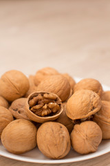 walnuts on a white plate on a woodden table