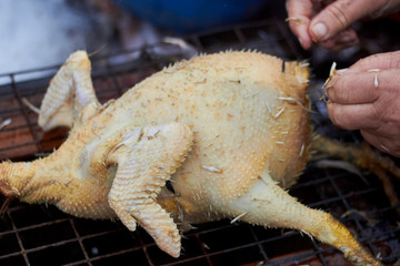Dead chicken on the table. A farmer is grazing a chicken with your hands.  Cooking. Farm, countryside. chicken.