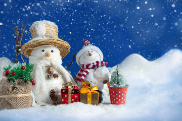 Snowman in a snowdrift with gifts for Christmas and New year