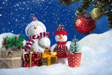Snowman in a snowdrift with gifts for Christmas and New year